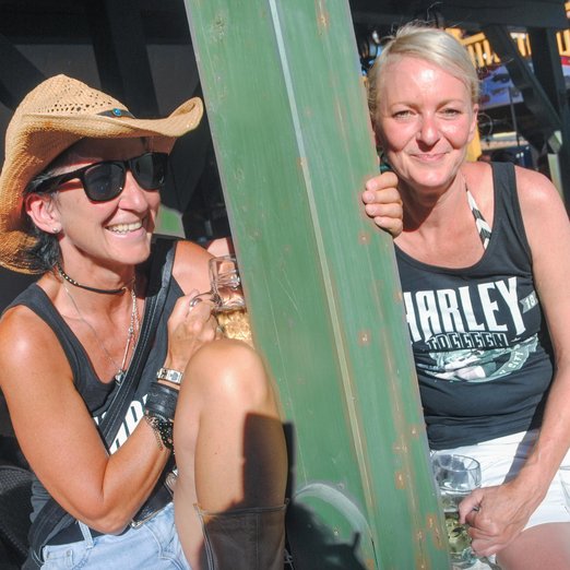 Zwei Frauen sitzen mit Bier auf einer Veranda