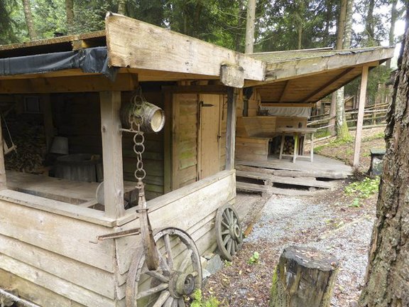Veranda eines Holzhauses mit angelehnten Wagenrädern