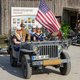 Personen sitzen in einem Jeep mit amerikanischer Flagge