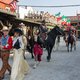 Männer in Cowboykleidund auf Pferden, Frauen in Kleidern im Stil des Wilden Westen