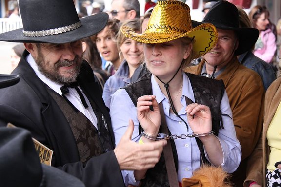 Frau mit Cowboyhut wird von Sheriff verhaftet