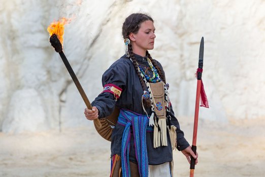 Frau in Indianerkleidung mit brennender Fackel