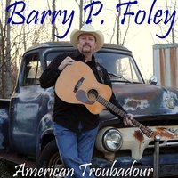 Barry P. Foley mit seiner Gitarre vor einem alten Auto