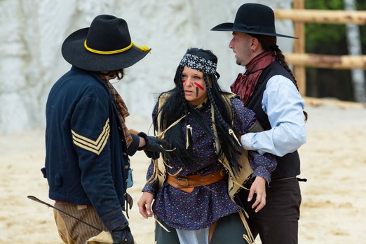 Zwei Cowboys halten eine Indianerfrau fest