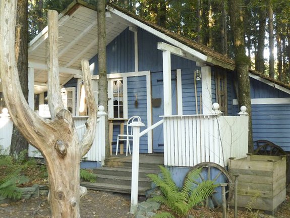 blau weißes Haus aus Holz mit Veranda 