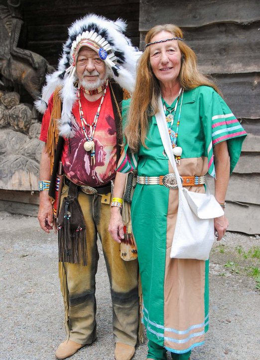 Mann mit Kopfschmuck aus Federn und Frau in Indianerkleidung