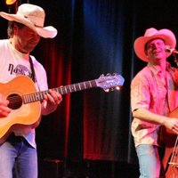 Zwei Männer mit Cowboyhüten, Gitarre und Cello