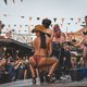 Frauen tanzen in Bikini während sie ein Motorrad waschen