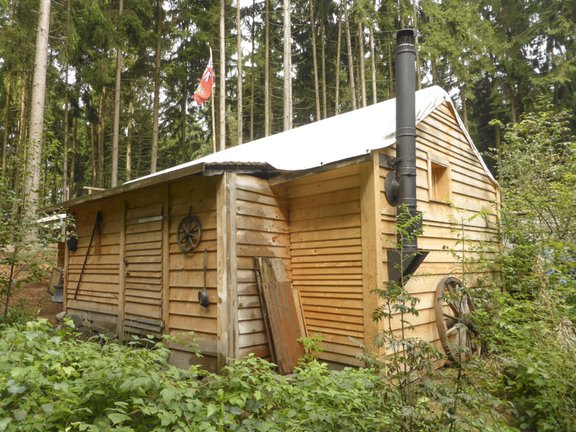 Holzhaus mit Plane über dem Dach