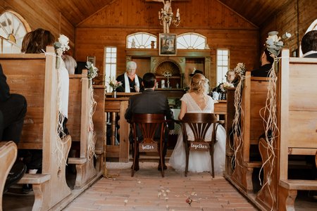 Braut und Bräutigam sitzen vor dem Alter