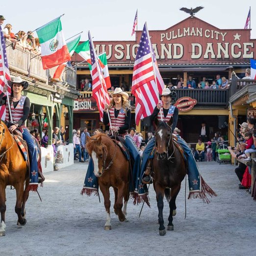 Menschen mit amerikanischer Flagge reiten auf Pferden