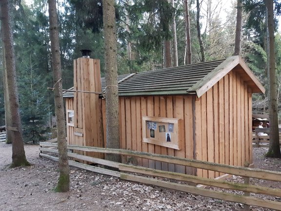 Holzhütte mit Schornstein in einem Wald