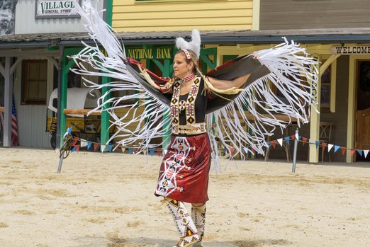 Frau in indianischer Kleidung führt traditionellen Tanz auf