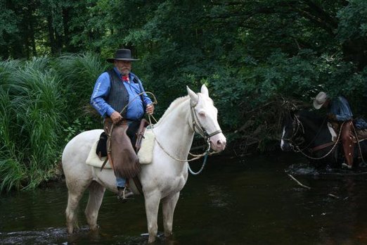 Mann in Cowboykleidung auf Pferd