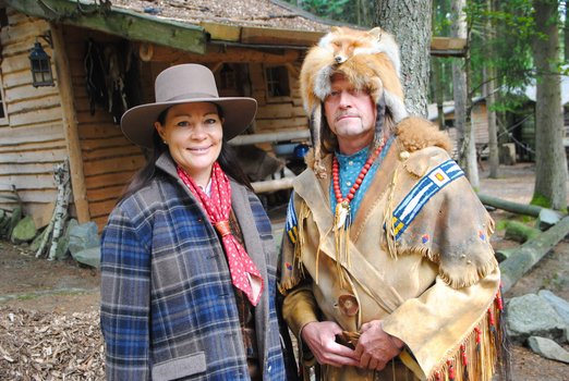Frau in Westernkleidung und Mann in Indianerkleidung mit Fuchs auf dem Kopf