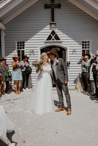 Brautpaar küsst sich vor der Kirche