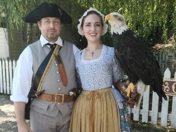 Mann mit Hut und Frau mit Adler auf dem Arm