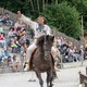 Mann reitet auf einem Pferd mit der Faust in die Luft gestreckt
