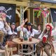 Piraten sitzen um einen Tisch vor einem Saloon der Westernstadt