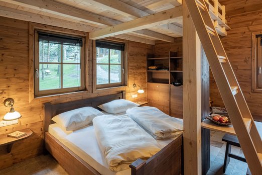 Schlafzimmer in einer Blockhütte mit Doppelbett