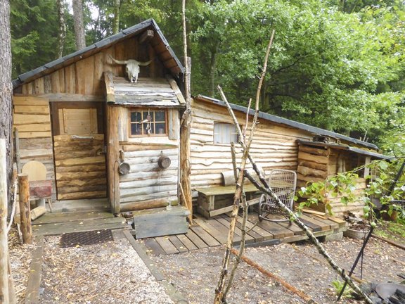 Hütte aus Holz im Wald, mit Tierschädel über Eingang