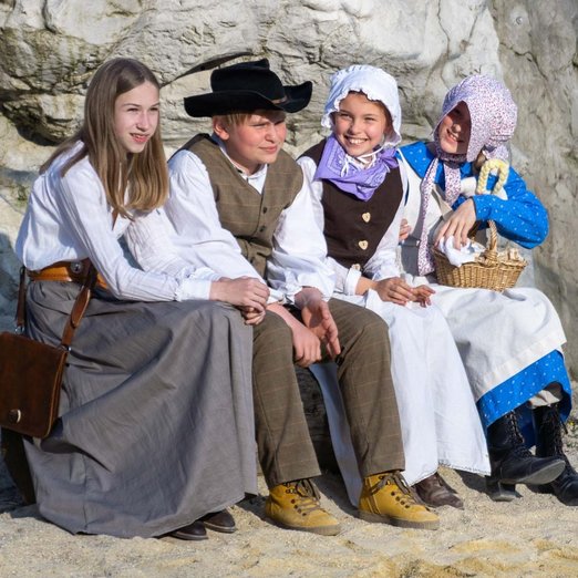 Vier Kinder in der Kleidung der Siedler des 19. Jahrunderts