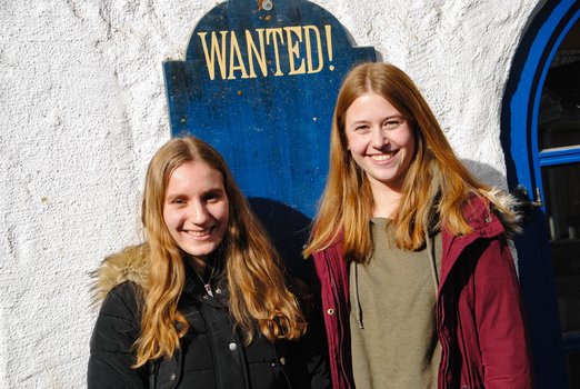 Zwei Mädchen vor einem "Wanted"-Schild