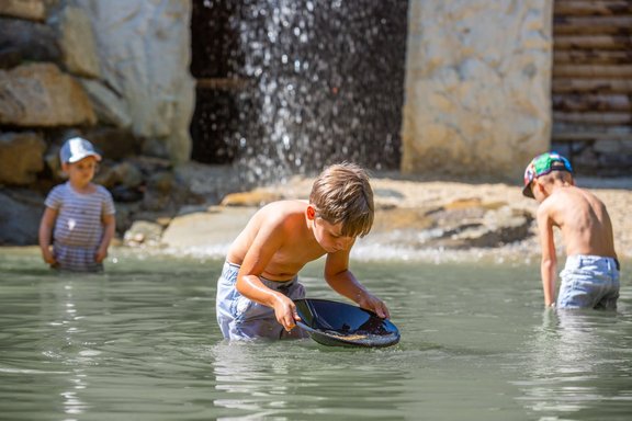 Kinder waschen Gold in einem Teich