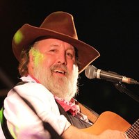 Mann in Cowboykleidung mit Gitarre 