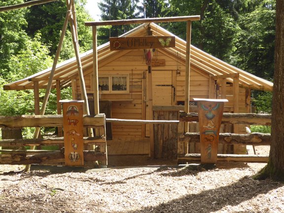 Hütte aus Holz, Zaun mit indianischen Verzierungen