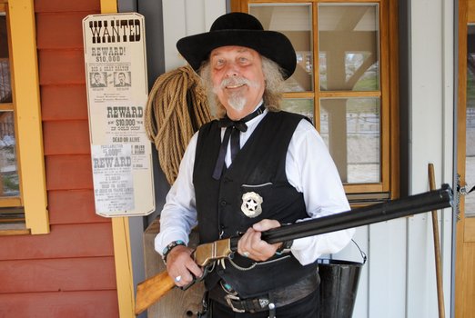Mann in Sheriffkleidung mit Gewehr
