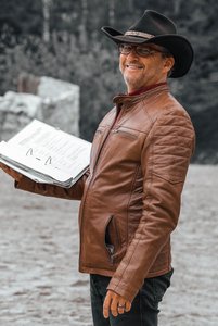 Mann mit Cowboyhut hält einen großen Ordner