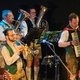 Bayerische Band mit Bleckblasinstrumente und Akkordeon, Musiker in Tracht