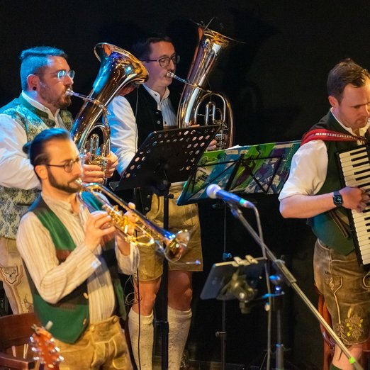 Bayerische Band mit Bleckblasinstrumente und Akkordeon, Musiker in Tracht