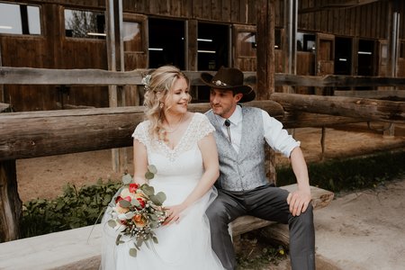 Brautpaar sitzt auf einer Holzbank