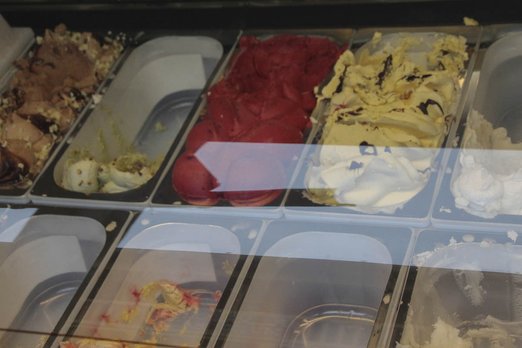 Verschiedene Eissorten in Behältern in einem Schaufenster