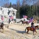 Vier Personen mit amerikanischen Flaggen reiten auf Pferden
